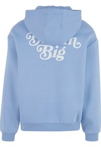Svetlomodrá mikina s kapucňou, predná klokanka, veľký biely nápis "Dream Big" na zadnej strane a rebrované manžety a lem. Mäkko pôsobiaca tkanina.