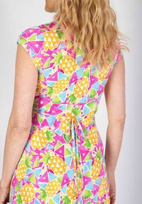 Färggklad kl�änning med ett livfullt ananas- och geometriskt mönster i rosa, gult, grönt och blått. Knytning i midjan och korta ärmar.