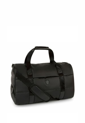 Bolsa de deporte acolchada negra con asas dobles, correa de hombro ajustable con almohadilla, bolsillos con cremallera y logo en forma de escudo en la parte delantera.