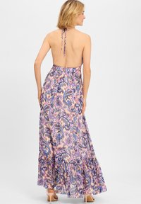 Maxi-Kleid mit einem lebhaften lila und rosa Paisleymuster, design mit Halsband, tiefem Rückenausschnitt und Rüschensaum.