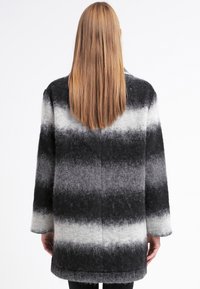 Abrigo de mezcla de lana en gris y negro con un patrón de rayas en degradado. Presenta un corte holgado, mangas largas y un acabado texturizado.
