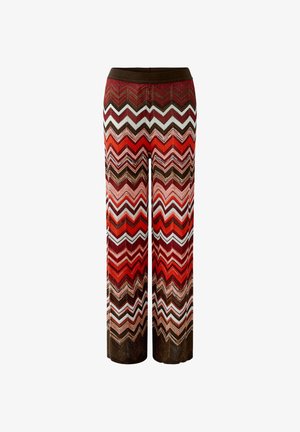 Wijde broek met een zigzagpatroon in tinten rood, bruin, oranje en wit, met een donkerbruine tailleband.