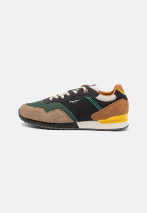 Multicolor sneaker featuring a mix of suede and nylon in green, black, and brown with yellow accents and a textured outsole.