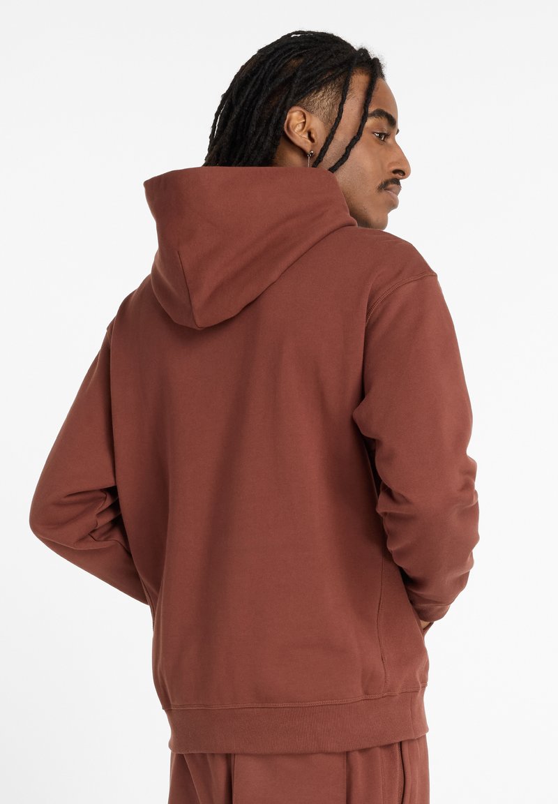 Maroon hoodie with a drawstring hood, ribbed cuffs, and hem. Soft texture, minimalistic design, and a relaxed fit.