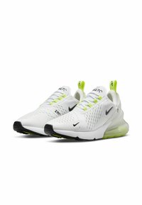 Zapatillas Nike Air Max 270 con parte superior de malla blanca, logo negro, acentos en amarillo brillante y una unidad de amortiguación de aire visible en el talón.