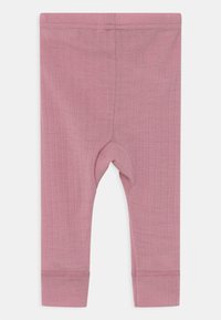 Leggings côtelés rose pâle avec une taille élastique et des poignets aux chevilles. Texture lisse avec une coupe ajustée et un renforcement au genou.