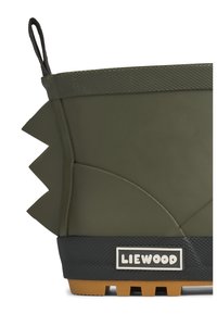 Botte en caoutchouc verte avec des accents texturés, des formes latérales courbées et des éléments de design épineux, dotée d'une base noire avec une étiquette logo.