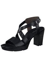 Svarta läder högklackade sandaler med korsande remmar, öppen tå och en texturerad blockklack. Utrustad med en silver spänne accent.