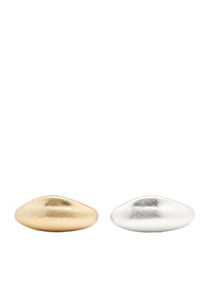 Een paar kleine, gladde keramische decoratieve stenen in goud en zilver, elk met een glanzende afwerking en een afgeronde, langwerpige vorm.