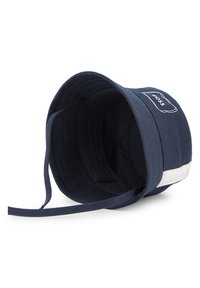 Κουκούλα τύπου κάπελο σε ναυτικό μπλε από βαμβάκι με φαρδύ γείσο, με λευκό λογότυπο και λευκή διακριτική λωρίδα στο πλάι. Εσωτερικό επενδεδυμένο.