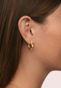 Goldene Creolen mit einem strukturierten, miteinander verflochtenen Design, das eine polierte Oberfläche und eine kompakte, runde Form zeigt.