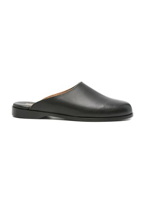 Zwarte leren slip-on mule met platte zool en gesloten ronde neus, zijaanzicht op witte achtergrond.