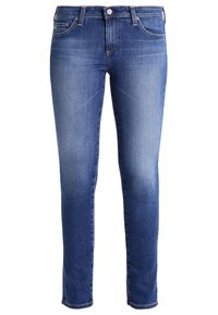 Smala jeans i medelblå denim. Har en klassisk femfickdesign med dragkedja, knappstängning och subtila urtvättning längs benen.