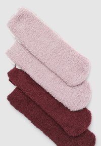 Calzini pelosi in tonalità rosa chiaro e borgogna, con una superficie morbida e testurizzata e bordi arrotondati. Tre paia impilati orizzontalmente.