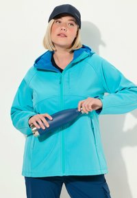 Ljusblå softshell-jacka med zippered framsida, huva och kontrasterande innerfoder, ihop parat med en mörkblå isolerad vattenflaska.