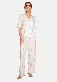 Loungewear set in soft, lightweight fabric featuring a collared short-sleeve top and long pants. Design includes pastel stars and splatter patterns.