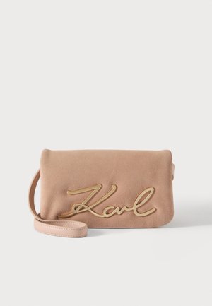 Pochette en daim beige avec une sangle poignet et un grand logo doré "Karl" en écriture cursive sur le devant.