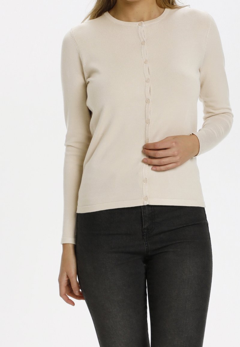 Ljusbeige långärmad cardigan med rund halsringning, knäppning framtill och ribbade muddar, tillverkad av ett mjukt, stretchigt tyg.