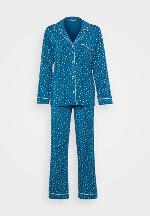 Conjunto de pijama azul composto por uma camisola de botão e calças combinando. O tecido apresenta um padrão de estrelas, com bainhas brancas nas bordas.