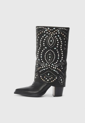 Botte en cuir noir avec un bout pointu, ornée de clous métalliques et d'accents turquoise dans un motif décoratif. Design à talon bloc.