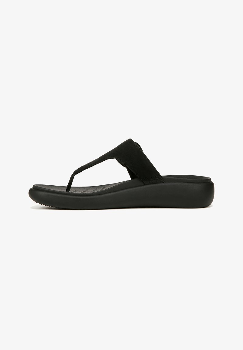 Sandale noire à talon compensé avec semelle rembourrée et large bride en tissu sur le coup de pied sur fond blanc.