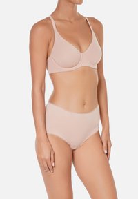 Soutien-gorge en coton rose clair avec coques moulées et bretelles ajustables, associé à une culotte taille haute avec une ceinture élastique lisse.