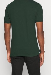 Dunkelgrünes Kurzarm-Cotton-T-Shirt mit taillierter Passform, gerundetem Halsausschnitt und genähtem Saum. Keine sichtbaren Muster oder Akzente.