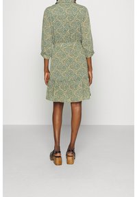 Vihreä paisley-kuosiset mekko, jossa on kolmannelta neljännekseen hihat, vyötäröltä kireä ja liehukastakin. Yhdistetty paksupohjaisten mustien korkokenkien kanssa.