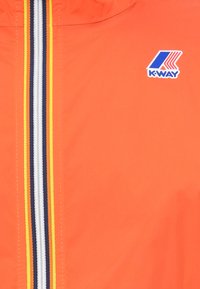 Chaqueta ligera naranja con el logo de K-way, que presenta un cierre frontal con detalles de rayas multicolores en azul marino, blanco y amarillo.