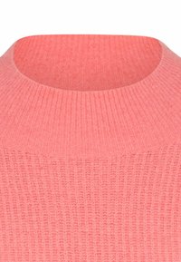 Rippstrickpullover in zartem Rosa mit hohem, rundem Ausschnitt und strukturierter Oberfläche. Hat ein figurbetontes Design und ein weiches Material.