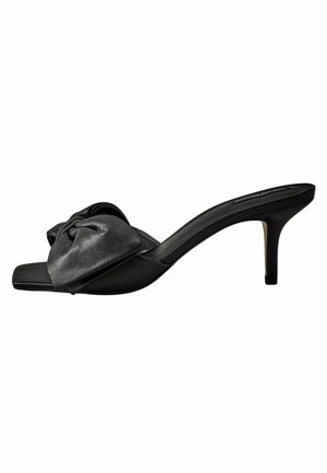 Black leather heeled sandal featuring a bow accent on the wide strap, open toe design, and a slim stiletto heel. Smooth texture overall.