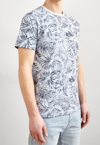 Short-sleeve, light blue t-shirt with dark blue tropical leaf pattern. Crew neck design, made from soft cotton fabric.