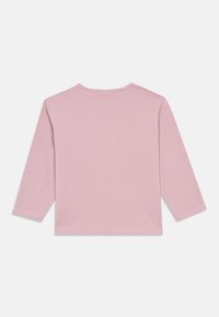 Koszula z długim rękawem w miękkim różowym materiale. Prosty fason z okrągłym dekoltem i przeszytym dołem, bez widocznych grafik czy wzorów.