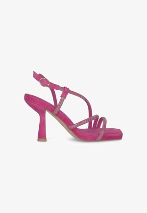 Pink suede heeled sandal with a square toe, thin straps, and rhinestone accents. Features an adjustable ankle strap and a tapered heel.