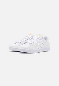 Vita lädersneakers med rund tå, platta snören, perforerade detaljer på sidorna, präglad logotyp på sidan och vadderad krage.