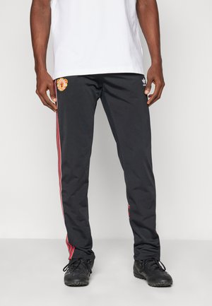 Black athletic pants with red stripes along the sides, featuring a logo on the upper left leg. Made of smooth, lightweight material.