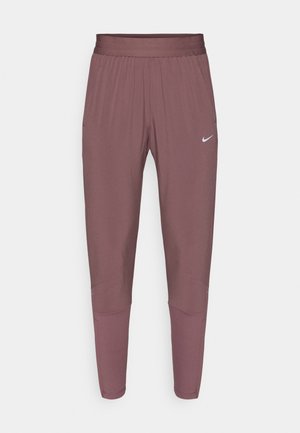 Pantalon de sport Nike de couleur bordeaux douce, avec une ceinture élastique, des jambes fuselées et un détail de marque subtil en blanc.