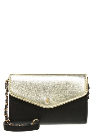 Pulsera de cuero negro con solapa metálica dorada y una correa de cadena negra y dorada unida al lado.