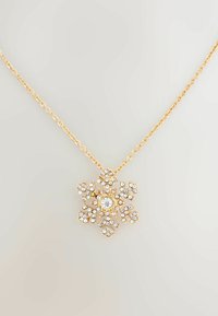 Gold chain necklace featuring a snowflake pendant adorned with small clear rhinestones, central stone, and intricate detailing.