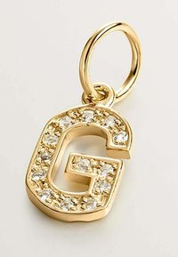Charm inicial "G" bañado en oro con rhinestones claros en un diseño texturizado. Asa metálica redonda para su sujeción.