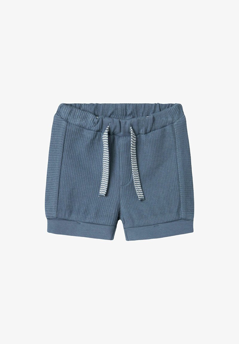 Mėlynos medvilninės šortai su tekstūruotu dizainu, elastinga juosmena ir balta raišteliu. Turi siaurėjantį siluetą ir kontrastingus kraštus.