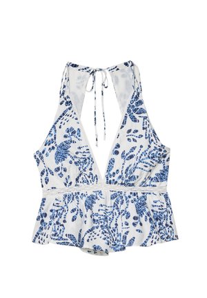 Valkoinen hihaton paita, jossa on sininen trooppinen lehtikuvio, syvä V-pääntie, solmittu selästä ja peplum-helma vyötäröllä. Kevyt kangas.