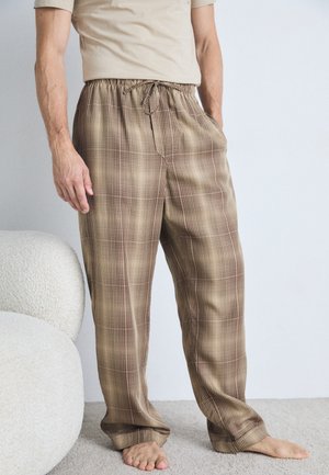 Pantalons à carreaux marron en tissu doux, dotés d'une taille élastique avec un cordon de serrage et de poches latérales. Longs jusqu'au sol et amples.
