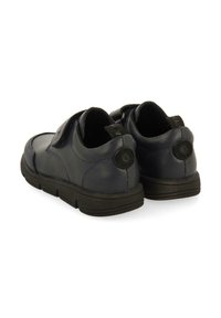 Chaussures en cuir bleu marine avec une finition texturée, bout arrondi et semelle en caoutchouc noir. Elles disposent d'une sangle à crochets et de logos circulaires en accent.