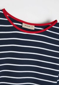 Granatowa koszulka w paski z białymi poziomymi paskami i czerwonym okrągłym dekoltem. Materiał jest gładki, z metką wskazującą rozmiar M.