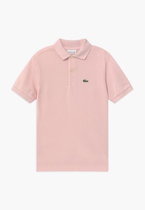 Polo rose clair en tissu texturé, avec un col, deux boutons et un logo crocodile vert sur la poitrine gauche.
