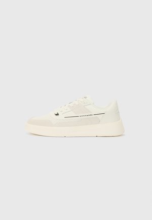 Vita sneakers i mesh och mocka-material, rund tå, snörning framtill, låg profil och logotypdetaljer på sidan och tungan.