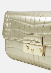 Sac à main en cuir gaufré de couleur or métallique, avec un motif de crocodile texturé, fermeture rabat et accents en métal doré.