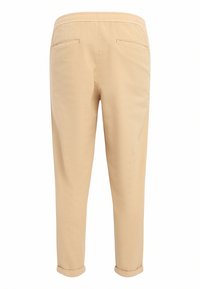 Pantalons beige clair à coupe décontractée, avec une taille élastique, deux poches arrière et des poignets retroussés, fabriqués à partir d'un tissu lisse.