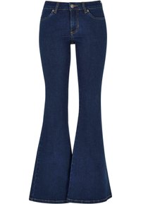 Donkerblauwe denim flared jeans hebben een hoge taille, voorkantzakken en contrasterende gele stiksels. De flared onderkant wordt geleidelijk breder.
